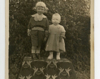 Vintage photo &#39;On a Pedestal&#39; haunting RPPC format picture of two kids posing on a decorative pedestal