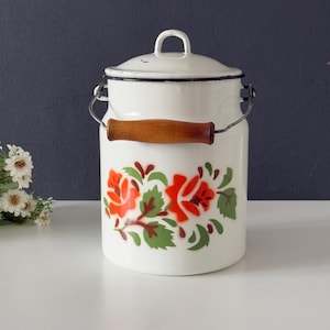 May include: White enamel milk can with a wooden handle and a floral design featuring red and green roses.