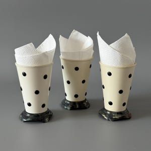 Puede incluir: Una taza de cerámica blanca con un asa negra y el texto "But First, Coffee" en negro, en negrita. La taza está sobre una superficie blanca.