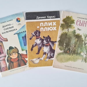 May include: Three vintage children's books with colorful illustrations. The covers feature images of a boy in winter clothing, two dogs, and a forest scene. Titles are in Russian.