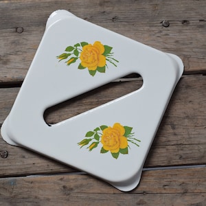 Könnte beinhalten: Weißes, quadratisches Tablett mit Griffaussparung, verziert mit gelben Rosenblütenmustern. Das Tablett steht auf einer rustikalen Holzoberfläche. Die Rosen haben grüne Blätter und gelbe Knospen.