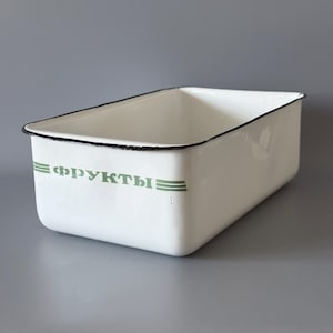 May include: A rectangular white enamel storage bin with a black rim. The front features the green Cyrillic text "ФРУКТЫ" flanked by two horizontal green lines. The container has rounded corners and a smooth, glossy finish throughout its exterior.