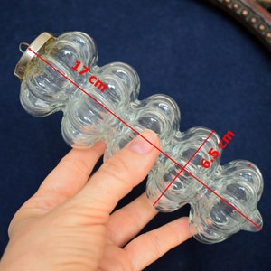 Puede incluir: Un adorno de vidrio transparente con forma de una serie de burbujas conectadas. Mide 6,5 cm de largo y 17 cm de alto.