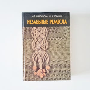May include: A vintage book titled "Nezabytye Remesla" with a cover featuring a macrame design in shades of brown and beige. The book's spine is black with orange text. The cover has a textured, woven appearance.
