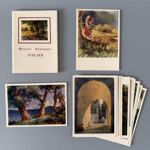 Op de afbeelding: Een verzameling vintage ansichtkaarten en een klein boek. De ansichtkaarten tonen landschapsschilderijen met figuren, bomen en water. Het boek heeft een landschapsafbeelding op de omslag en tekst in het Russisch. De items zijn gerangschikt op een grijze ondergrond.