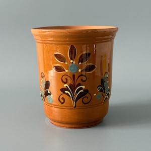 Op de afbeelding: Een set van drie keramische mokken met een gespikkelde, matte afwerking. Elke mok heeft een andere kleur: lichtblauw, crème en grijs. De mokken hebben een eenvoudig, modern ontwerp.