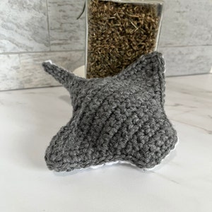 May include: Gray crocheted stingray toy with white edging.