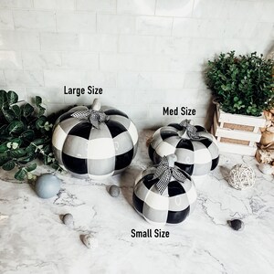 May include: Three ceramic pumpkins in black and white checkered pattern. The pumpkins are in different sizes, labeled "Large Size", "Med Size", and "Small Size".