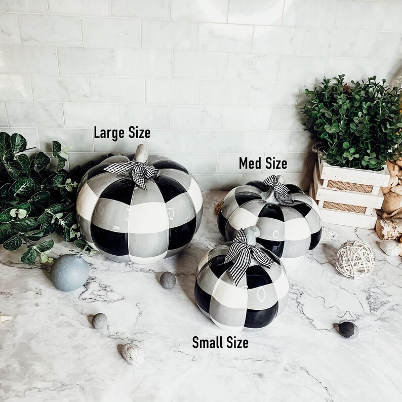 May include: Three ceramic pumpkins in black and white checkered pattern. The pumpkins are in different sizes, labeled "Large Size", "Med Size", and "Small Size".