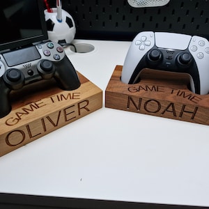 May include: Two wooden game controller stands with personalised names "Oliver" and "Noah" and the text "Game Time".