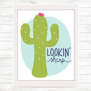 May include: A green cactus with a pink flower on top, against a light blue background. The text "LOOKIN' sharp" is written in dark blue below the cactus.