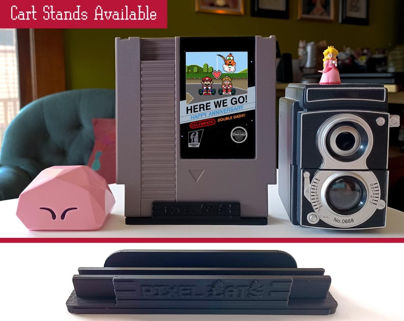 May include: Three different types of stands for video game cartridges. The stands are black and gray and have the text "Pixel Stand" printed on them. The stands are designed to hold video game cartridges upright.