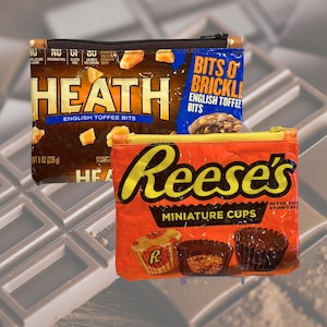 May include: Three zippered pouches made from candy wrappers. One pouch is brown with "HEATH ENGLISH TOFFEE BITS" printed on it. Another is orange with "Reese's MINIATURE CUPS" printed on it. A third pouch is blue with "BITS O' BRICKLE ENGLISH TOFFEE BITS" printed on it.