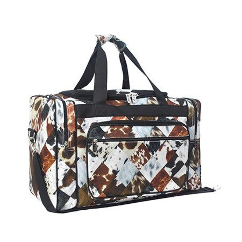 May include: A black and brown travel duffel bag with a patchwork design featuring a cowhide pattern. The bag has two top handles and a zippered closure.