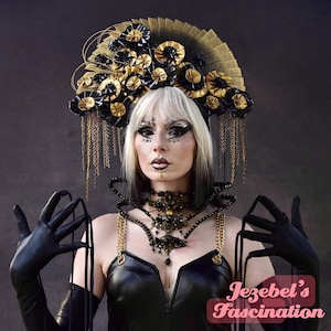 Puede incluir: Una persona con un top y guantes de cuero negro, adornada con un tocado decorativo con detalles dorados y negros. El tocado se complementa con un collar a juego con detalles de cadena dorada. La imagen incluye el texto "Jezebel's Fascination".