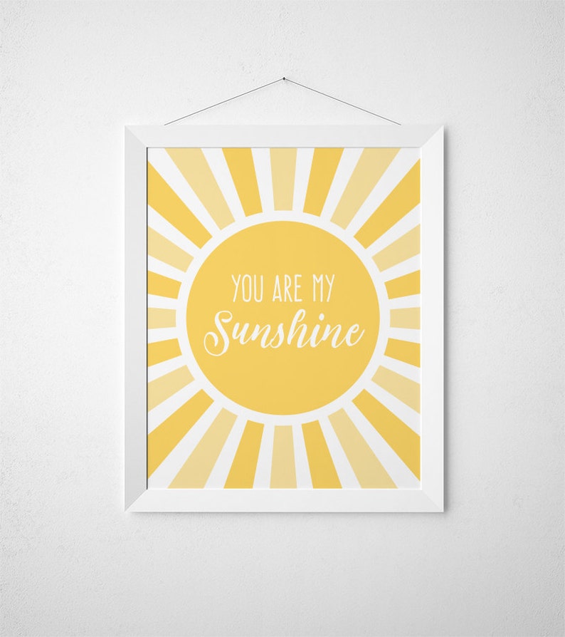 Puede incluir: Una impresi&oacute;n enmarcada en blanco con un dise&ntilde;o de sol amarillo y el texto "You are my Sunshine" en blanco.