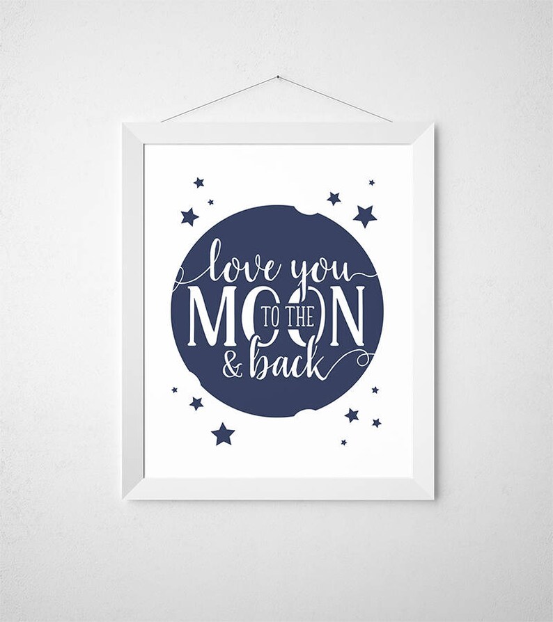 May include: A white framed print with a navy blue circle and white text that reads "love you to the moon & back". The circle is surrounded by small white stars.
