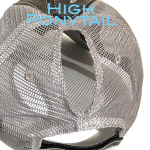 May include: Gray and black mesh baseball cap with a high ponytail opening in the back. The cap has a black adjustable strap.