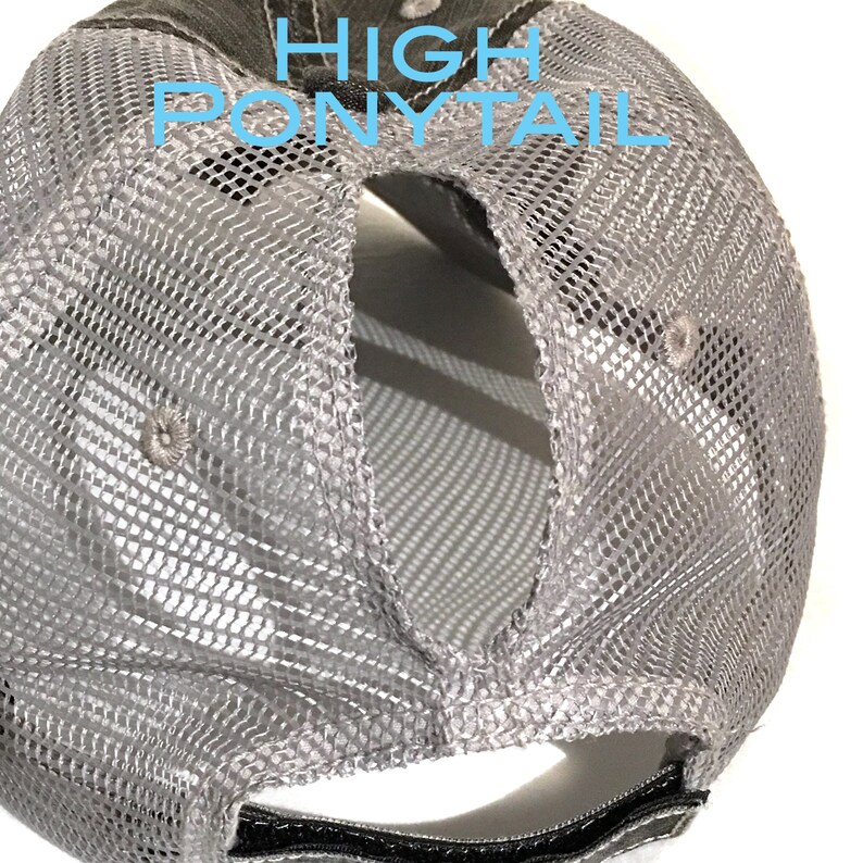 May include: Gray and black mesh baseball cap with a high ponytail opening in the back. The cap has a black adjustable strap.