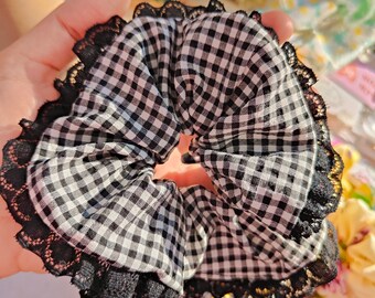 Schwarz-weißes Vichy-Haargummi mit Spitze. Scrunchies mit Spitzenbesatz. Haarschmuck. Blond. Gemälde. Spitzenband.