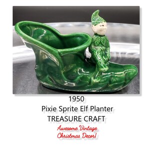 May include: A green ceramic planter shaped like a shoe with a small green elf sitting on top. The planter is labeled "1950 Pixie Sprite Elf Planter TREASURE CRAFT Awesome Vintage Christmas Decor!"