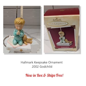 May include: Hallmark Keepsake ornament from 2002. The ornament features a child in blue pajamas kneeling in prayer on a book, with a small teddy bear. The ornament is in its original box, which is also shown in the image.