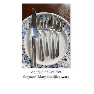 May include: Antique 55 piece set of Craydon-Mary Lee silverware on a white plate with a blue and white floral pattern.