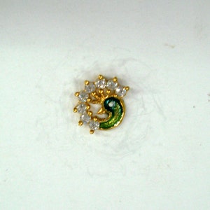 May include: A gold nose ring featuring a peacock design. The peacock is green and blue with white rhinestones around it.