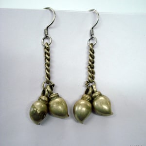 May include: A pair of silver earrings with a twisted chain design and three silver bell-shaped charms at the bottom.