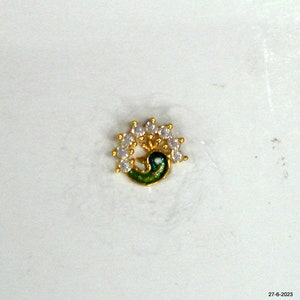 May include: A gold nose ring featuring a peacock design with white cubic zirconia stones.
