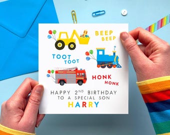 May include: A birthday card with colorful illustrations of a yellow digger, a blue train, and a red fire truck. The card reads "Happy 2nd Birthday to a Special Son Harry."