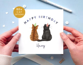 May include: A square white birthday greeting card featuring an illustration of a brown tabby cat and a black cat sitting side-by-side, both wearing small party hats. The text reads "HAPPY BIRTHDAY" in blue and "Harry" in black script.