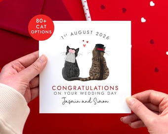 May include: A square wedding greeting card featuring two cats sitting side-by-side. One black cat wears a pink floral veil, and one brown tabby cat wears a black top hat with a red band. Text reads 1ST AUGUST 2026, CONGRATULATIONS ON YOUR WEDDING DAY, and Jasmin and Simon.