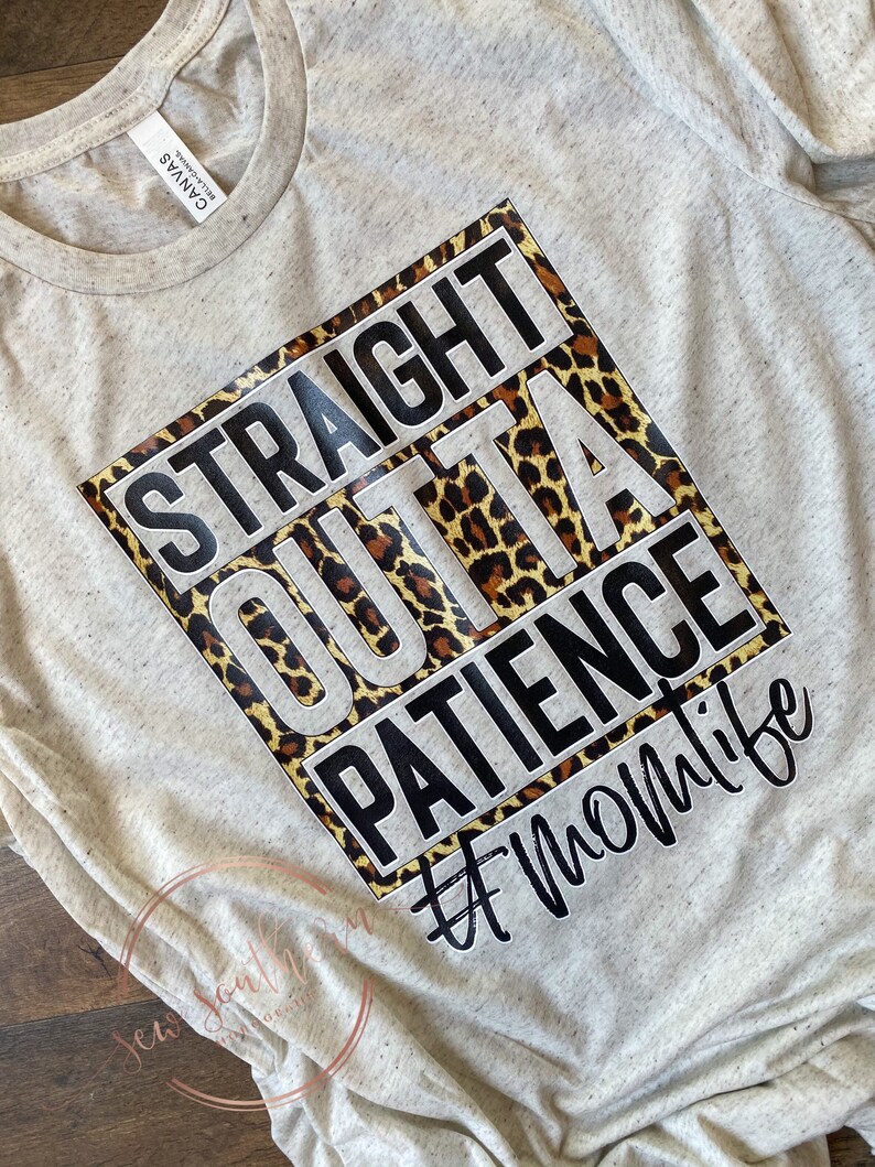 K&ouml;nnte beinhalten: Ein hellgraues T-Shirt mit einer schwarzen quadratischen Grafik, auf der "Straight Outta Patience #Momlife" steht. Die Grafik hat einen Leopardenmuster-Hintergrund.