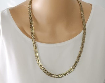 May include: A gold, silver, and bronze braided chain necklace. The necklace is on a white mannequin.