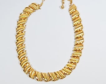 May include: A gold-tone necklace with a chain made of interlocking leaf-shaped links.