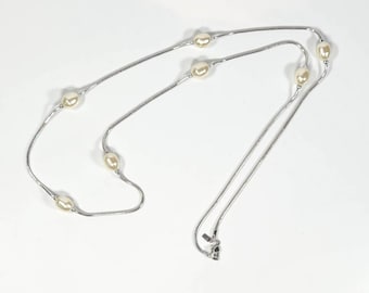 May include: A silver chain necklace with five white pearl beads.