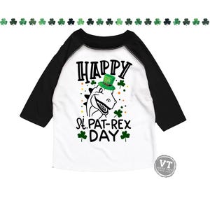May include: A white and black baseball tee shirt with a green dinosaur wearing a green leprechaun hat. The shirt says "Happy St. Pat-Rex Day" in black text with green shamrocks.