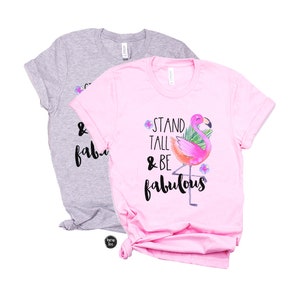 May include: Two t-shirts, one pink and one grey, with a flamingo graphic and the text "Stand Tall & Be Fabulous".