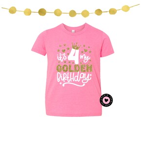 May include: Pink t-shirt with the text "It's my 4 Golden Birthday" in gold glitter and white script. The design includes a gold crown and stars. A gold garland hangs above the shirt.
