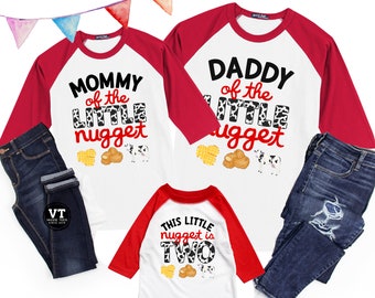 May include: A set of three red and white baseball t-shirts with a chicken nugget theme. The shirts say "Mommy of the Little Nugget", "Daddy of the Little Nugget", and "This Little Nugget is Two".