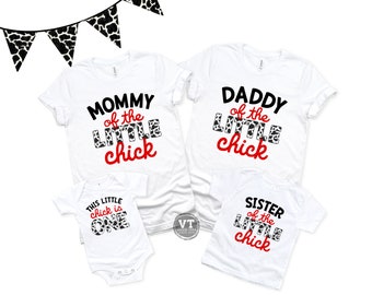 Könnte beinhalten: Weiße T-Shirts mit schwarzem und weißem Kuhmuster-Text, der "Mama vom kleinen Küken", "Papa vom kleinen Küken", "Schwester vom kleinen Küken" und "Dieses kleine Küken ist eins" lautet.