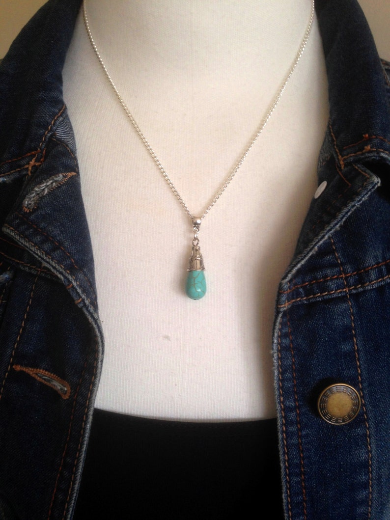 Puede incluir: Un collar de cadena de plata con un colgante de l&aacute;grima turquesa.