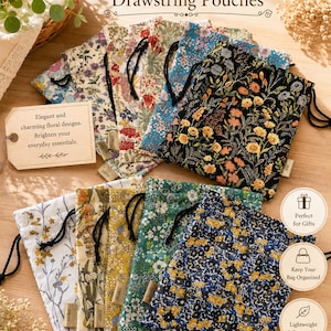 Könnte beinhalten: Eine Sammlung rechteckiger Beutel mit Kordelzug und verschiedenen Blumenmustern in Farben wie Schwarz, Blau, Grün, Gelb und Weiß. Jeder Beutel hat einen schwarzen Kordelzug und ein kleines Stoffetikett. Der Text lautet Botanical Drawstring Pouches.