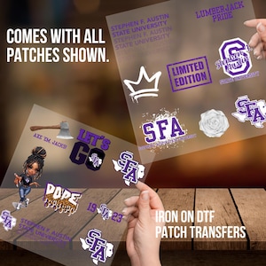 May include: A set of iron-on patch transfers featuring a variety of designs, including a crown, a rose, a Texas-shaped outline, and a logo for Stephen F. Austin State University. The patches are purple and white and come with instructions for applying them to fabric.