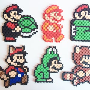 May include: Six different pixel art characters from the Super Mario Bros. video game series. The characters are made of colorful plastic beads and include Mario, Luigi, Toad, and a turtle.