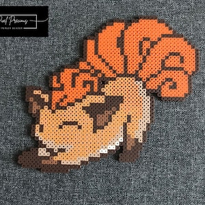 May include: A brown, orange and white pixel art design of a Pokemon character. The character is a brown and orange Snorlax with a white belly and a brown tail.