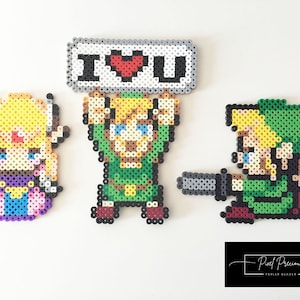 May include: Three pixel art figures made with perler beads. A green Link character holding a sign that says "I love you" with a red heart. A green Link character with a sword and a blonde Zelda character.