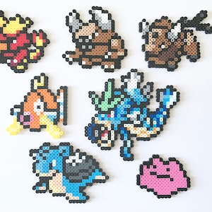 Könnte beinhalten: Sieben bunte Pixel-Kunstfiguren aus Perlen, darunter ein roter und gelber Drache, ein braunes Nashorn, eine blaue und grüne Seeschlange, ein rosa Klecks, ein brauner und gelber Fisch, eine blaue und schwarze Schildkröte und eine braune und gelbe Kreatur mit Hörnern.
