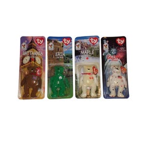 May include: Four Ty Beanie Baby bears in their original packaging. The bears are Britannia, Erin, Maple, and Glory. Each bear is a different color and has a flag or symbol on its chest. The packaging features images of Big Ben, the Statue of Liberty, and other landmarks.
